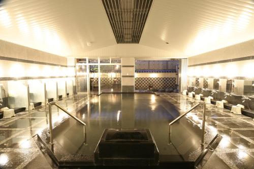 a pool in the middle of a building with chairs at Tosagyoen in Kochi