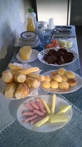 una tabella ricoperta di piatti di diversi tipi di alimenti di Pousada Ana Poipa a Goiânia