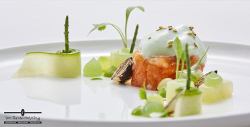a white plate with a dessert with plants on it at Der Zauberlehrling in Stuttgart