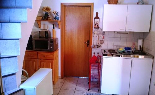 uma cozinha com armários brancos e um micro-ondas em Ferienhaus Brigitte em Klingenthal
