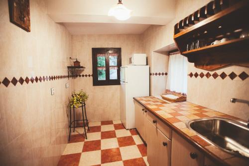 a kitchen with a refrigerator and a checkered floor at El Requexu, apartamentos a 900 m de la playa de Poo AR-0474-AS in Llanes
