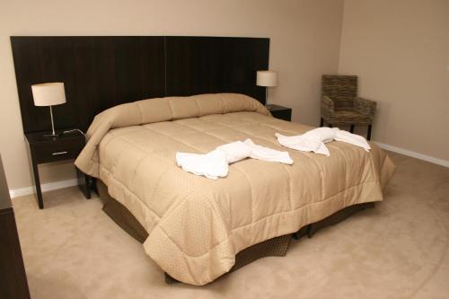 Un dormitorio con una cama grande con toallas blancas. en Hotel Casino Hue Melen, en Zapala