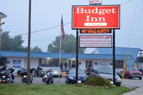 a no vacancy sign in front of a building with motorcycles at Budget Inn Marinette in Marinette