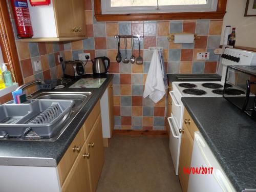 a kitchen with a sink and a stove at Forest Glen Holiday Park in Invermoriston