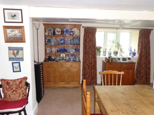 a dining room with a table and a kitchen at Lodge House B&B in Buckland St Mary