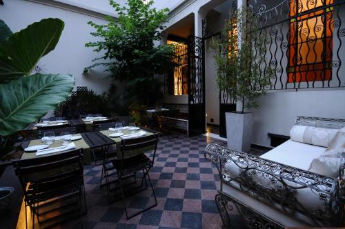 um restaurante com mesas, cadeiras e plantas em Casa Umare em Buenos Aires