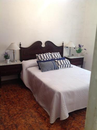 タラゴナにあるApartamento Tarragonaのベッドルーム1室(白い大型ベッド1台、ナイトスタンド2台付)