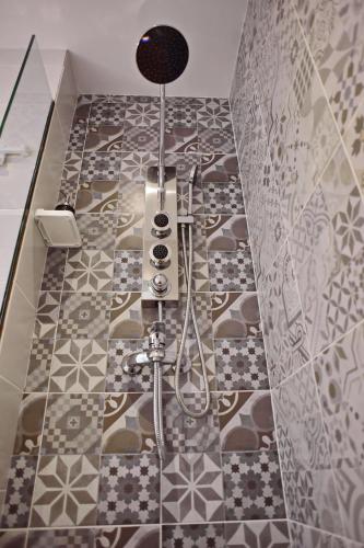 e bagno con doccia e pavimento piastrellato. di Villa Mariza 1920 a Città di Rodi