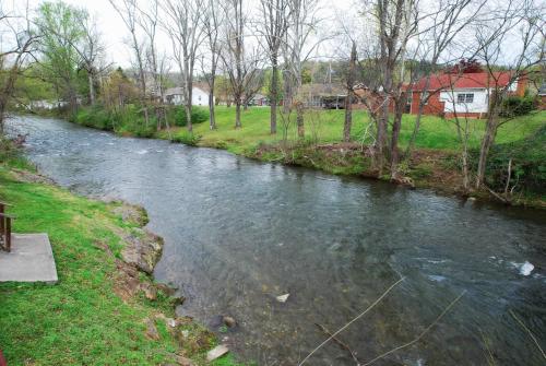 a stream of water with houses in the background at Rivergate Mountain Lodge in Pigeon Forge