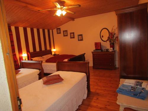 um quarto com 2 camas e uma ventoinha de tecto em La Piaule em Saint-Pierre-le-Vieux