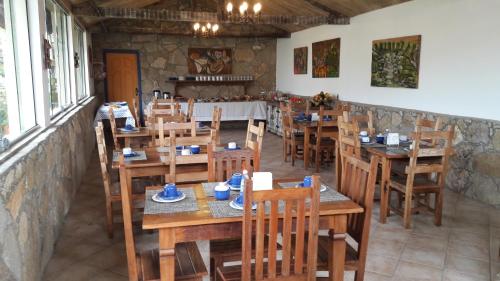 a restaurant with wooden tables and chairs in a room at Pousada Berço da Liberdade in Tiradentes