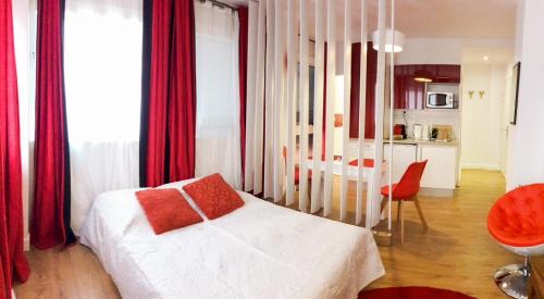 トゥールーズにあるStudio rouge Ramblas Centre Toulouseのベッドルーム(白いベッド1台、赤いカーテン付)