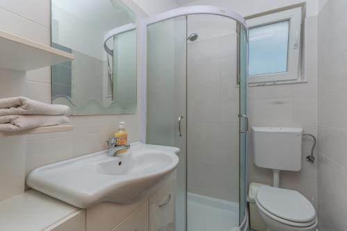 a bathroom with a sink and a shower and a toilet at Guest House Gloria in Novigrad Istria