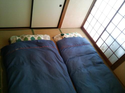 two beds in a room with a window at Hutte Lied in Komoro