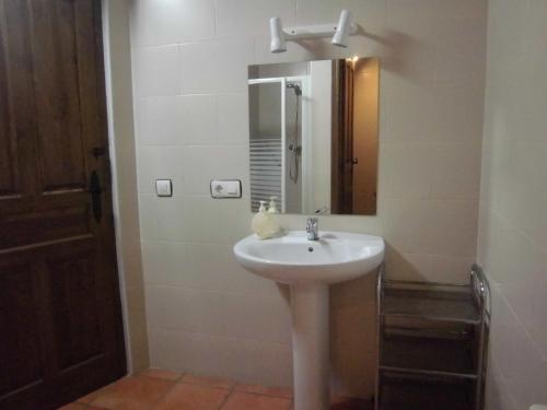 y baño con lavabo blanco y espejo. en Albergue Turístico Las Eras, en Barcial del Barco