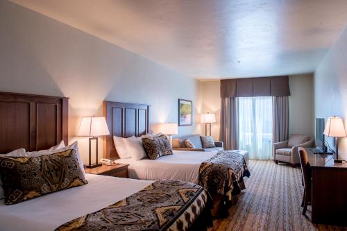 a hotel room with two beds and a couch at Cedar Creek Lodge & Conference Center in Columbia Falls