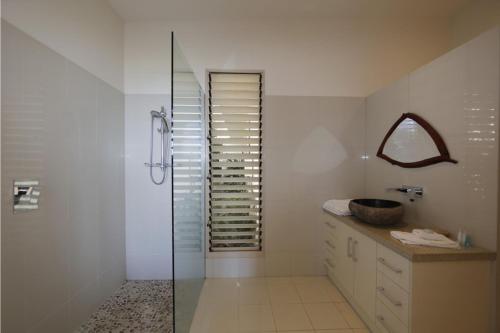 a bathroom with a glass shower and a sink at The Boat House in South Mission Beach