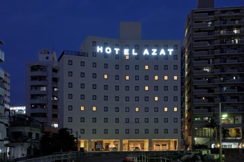 那覇市にあるホテル アザット 那覇の夜間のホテルの上に看板があります。