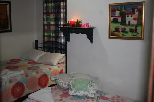 a bedroom with a bed and a candle on a shelf at Hospedaje La Casona in Tabio