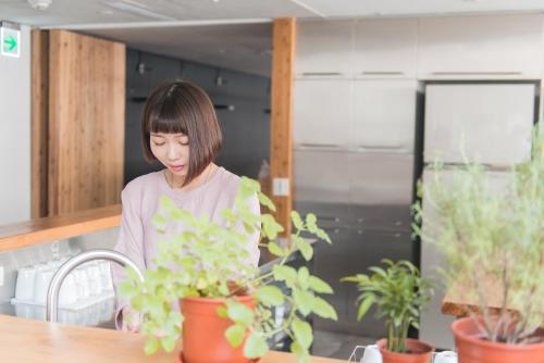 a woman standing in a kitchen looking at plants at Star Hostel Taipei Main Station in Taipei