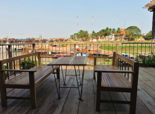 a table and two benches sitting on a deck at ST 63 Home Stay & Tour Kampong Khleang in Kâmpóng Khleăng