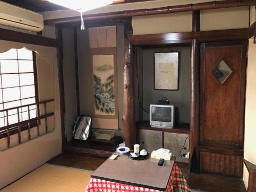 a living room with a table and a television at Niko Ryokan in Aizuwakamatsu