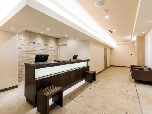 an office lobby with a reception desk and chairs at HOTEL MYSTAYS Sapporo Nakajima Park Annex in Sapporo