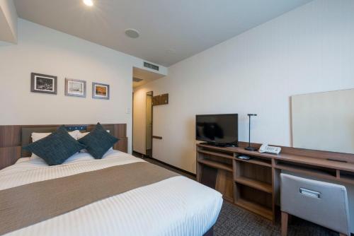 een hotelkamer met een bed en een televisie bij HOTEL MYSTAYS Sapporo Nakajima Park Annex in Sapporo