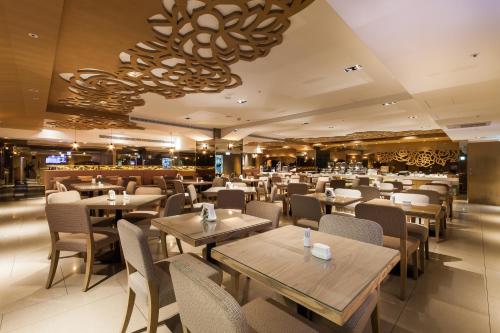 a restaurant with tables and chairs and a chandelier at Green World Taipei Station in Taipei