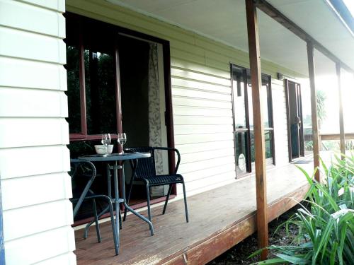 a porch with a table and chairs on it at Brook House B&B & Cottages in Kaikoura