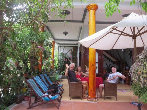 a group of people sitting in chairs under an umbrella at NGO KHANH Homestay in Tân Hiệp