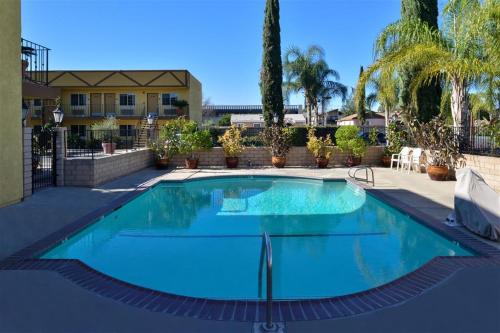 a swimming pool with blue water in front of a building at Americas Best Value Inn & Suites - Fontana in Fontana