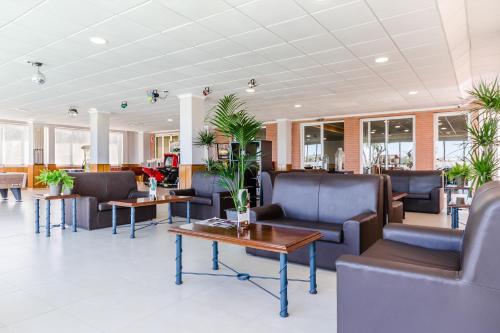 a waiting room with couches and tables and plants at Hotel Gran Playa in Santa Pola