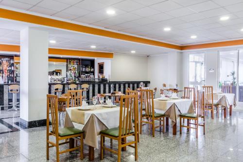a dining room with tables and chairs and a bar at Hotel Gran Playa in Santa Pola