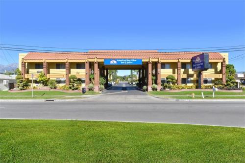 a large yellow building with a road in front of it at Americas Best Value Inn & Suites - Fontana in Fontana