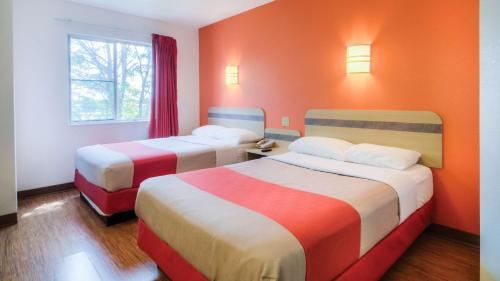 two beds in a room with orange walls at Motel 6-Owensboro, KY in Owensboro