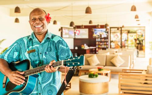 a man playing a guitar in a store at Tokatoka Resort Hotel in Nadi