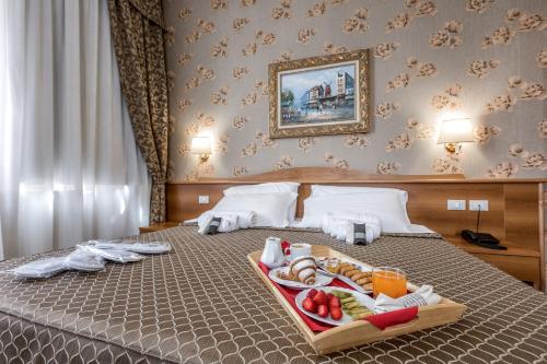 una habitación de hotel con una bandeja de comida en una cama en Hotel Sorriso en Lucera