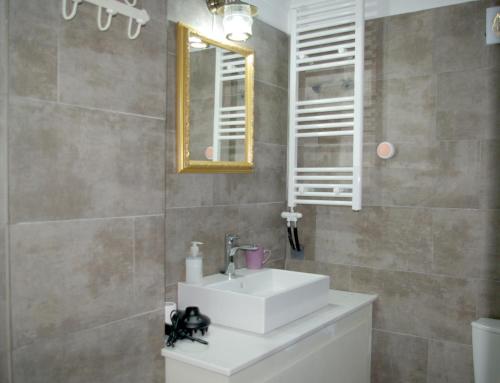 y baño con lavabo blanco y espejo. en Villa Vigles en Vóroi