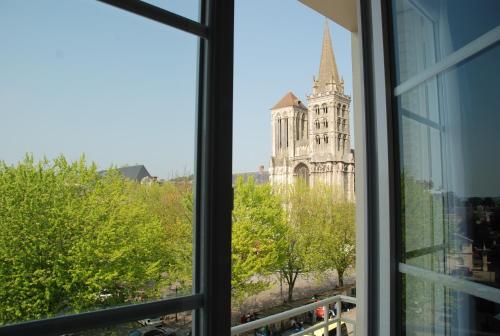 a window in a building with a view of the city at The Originals City, Hôtel Cathédrale, Lisieux (Inter-Hotel) in Lisieux