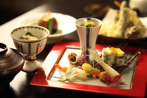 un plato de comida en una mesa con dos tazas en Chigira Jinsentei, en Shibukawa