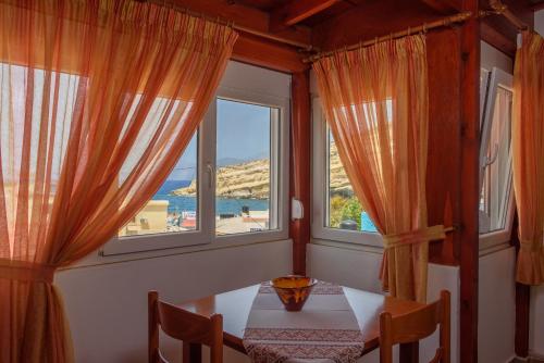 a room with a table, chairs and a window at Nikos Hotel in Matala