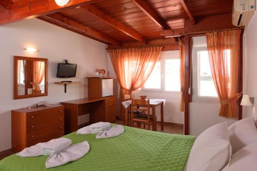 a bedroom with a bed and a television at Nikos Hotel in Matala