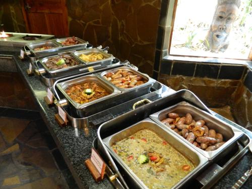 a buffet with several trays of food on a counter at Misty Hills Country Hotel, Conference Centre & Spa in Muldersdrift