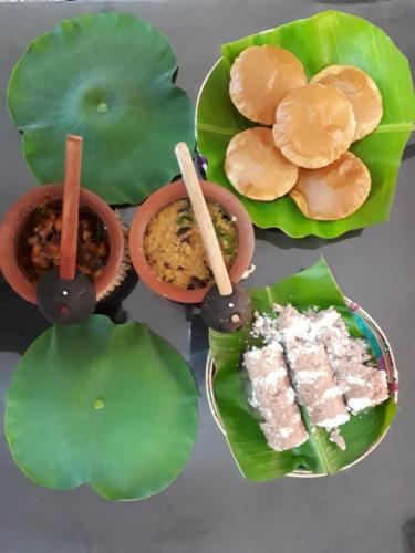 a group of plates of food sitting on leaves at Brinthavanam Days Inn in Jaffna