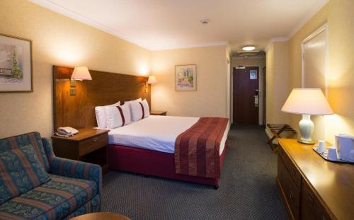 a hotel room with a bed and a chair at Coventry Hotel By Belvilla near City Centre in Coventry
