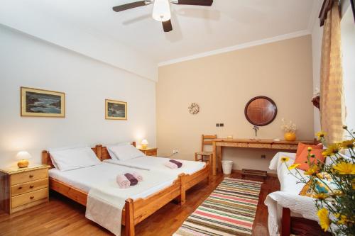 a bedroom with two beds and a table and a couch at Villa Melpomeni in Márpissa
