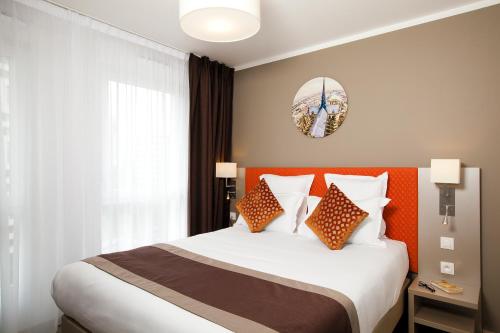 a bedroom with a large bed with an orange headboard at Residhome Paris Rosa Parks in Paris