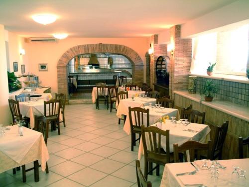 un restaurante con mesas y sillas con mantel blanco en New Hotel Sonia, en Santa Maria di Castellabate