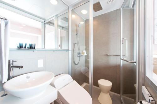 a bathroom with a shower and a toilet and a sink at remm Roppongi in Tokyo